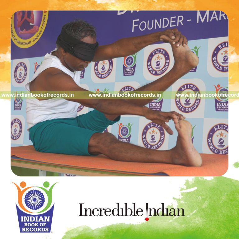 an individual holding vama purna akarna dhanurasana yoga pose blindfolded on a table continuously for the longest duration with stability and control for a record in Indian Book of Records