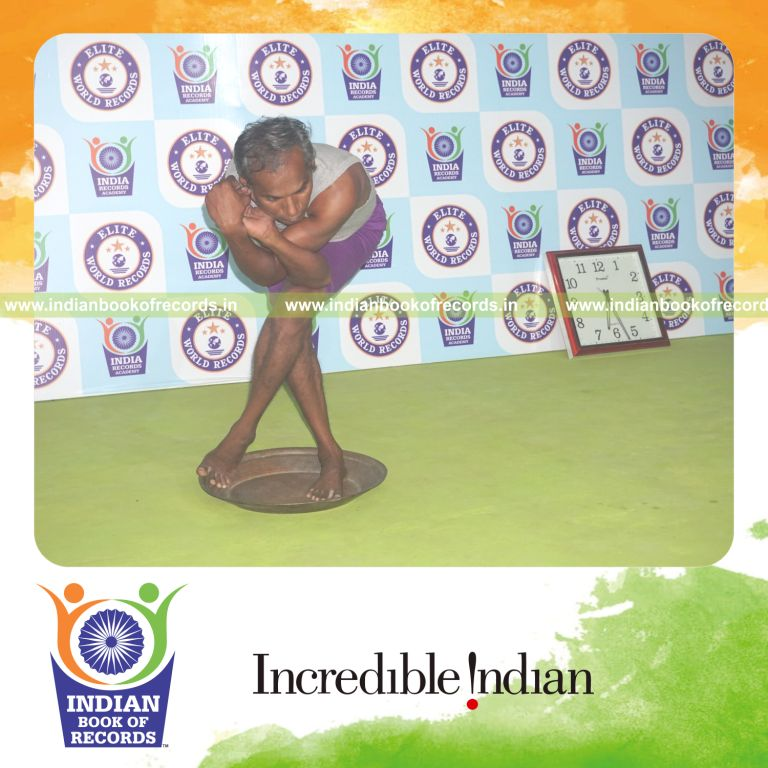 individual holding vama purna garudasana yoga pose on a brass plate for record in Indian Book of Records