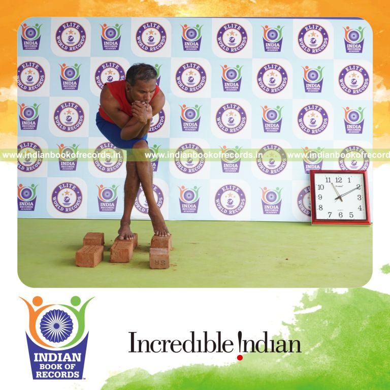 individual holding vama purna garudasana yoga pose on bricks for record in Indian Book of Records