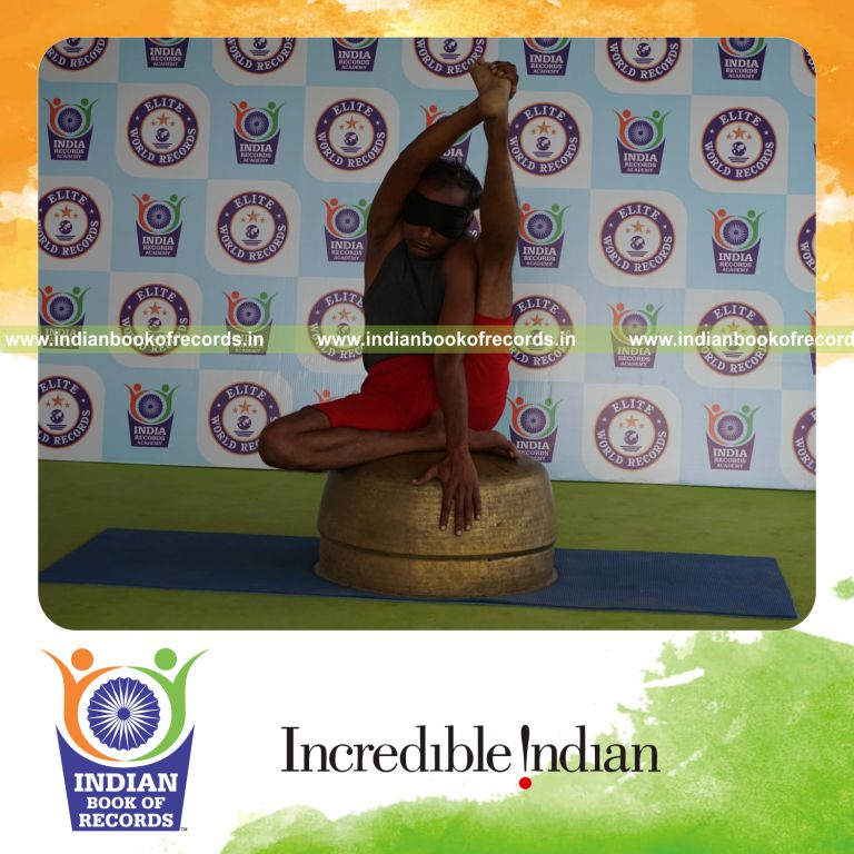 individual holding vama purna krounchasana yoga pose blindfolded on a vessel for record in Indian Book of Records