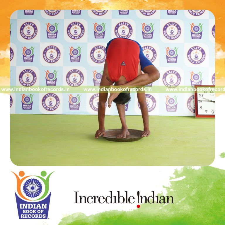 individual holding vama ruchikasana yoga pose on a brass plate for record in Indian Book of Records