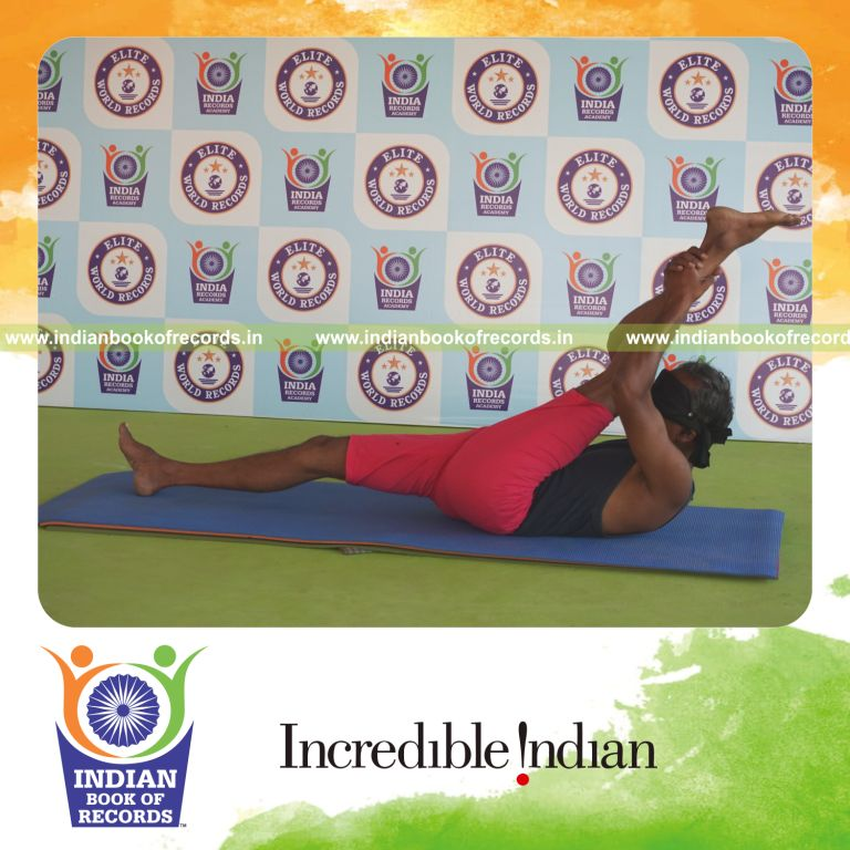 individual holding vama supta padangusthasana yoga pose blindfolded for record in Indian Book of Records