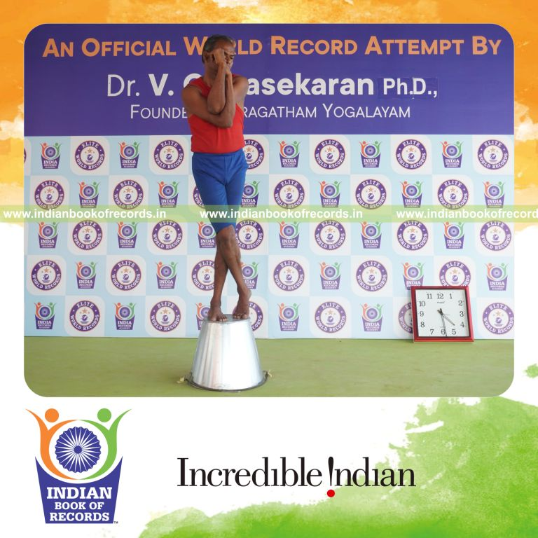 individual holding vama tada garudasana yoga pose on a bucket for record in Indian Book of Records