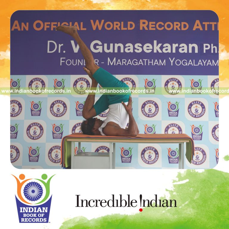 an individual holding vama utthita kadi ekapada chakrasana yoga pose blindfolded on a table continuously for the longest duration with balance and control for a record in Indian Book of Records