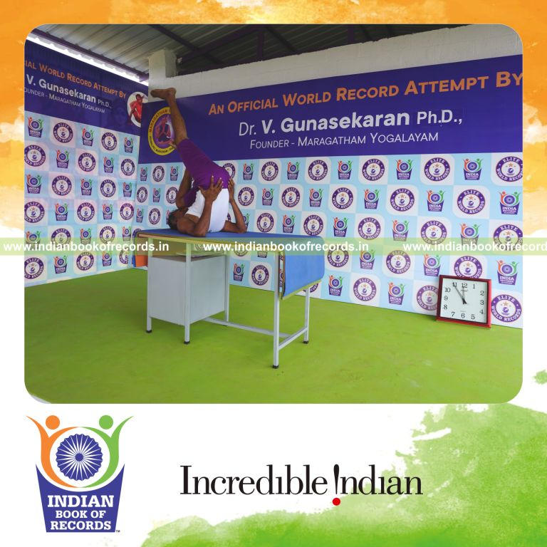 individual holding vama utthita kadi ekapada chakrasana yoga pose on a table for record in Indian Book of Records