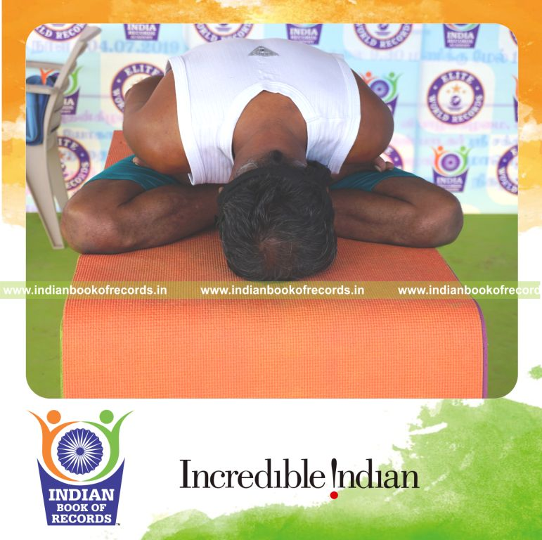 an individual holding yoga mudra yoga pose blindfolded on a table continuously for the longest duration with control and balance for a record in Indian Book of Records