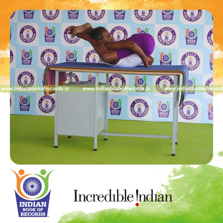 individual holding yoganidrasana yoga pose on a table for record in Indian Book of Records