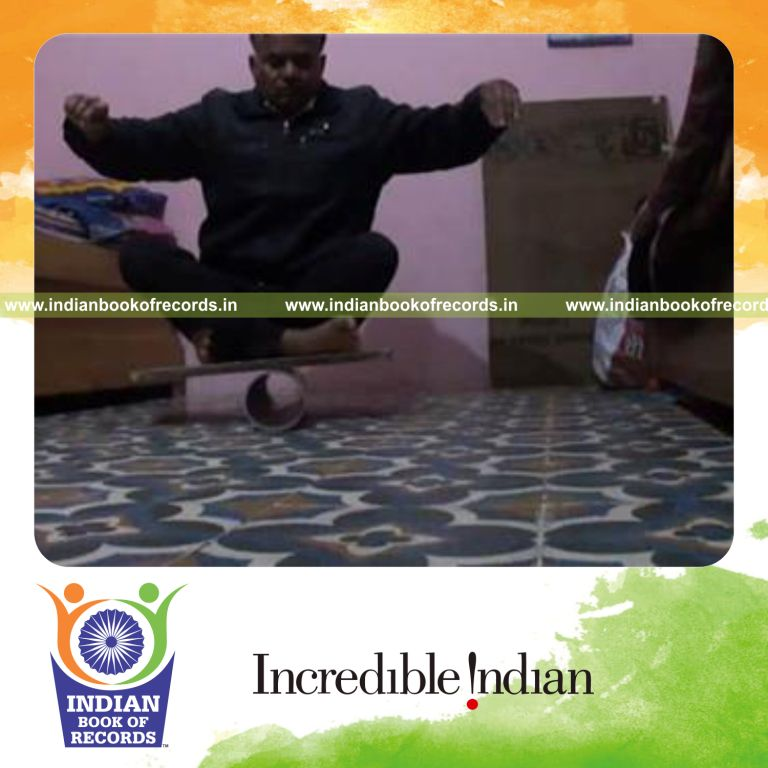 individual holding easy pose on balance board for record in Indian Book of Records