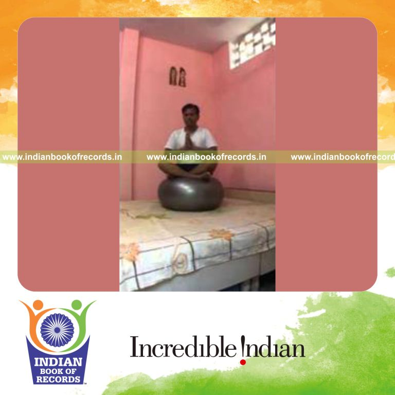 individual sitting on exercise ball holding easy pose for record in Indian Book of Records