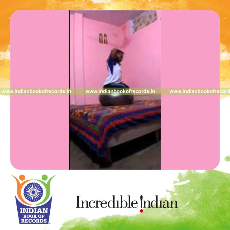 individual sitting on exercise ball holding lotus and cow face pose with clamped hands for record in Indian Book of Records