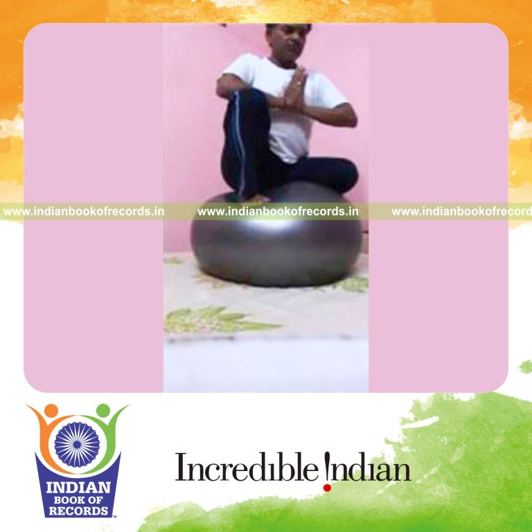 individual sitting on exercise ball holding vajra veerasana hero pose for record in Indian Book of Records