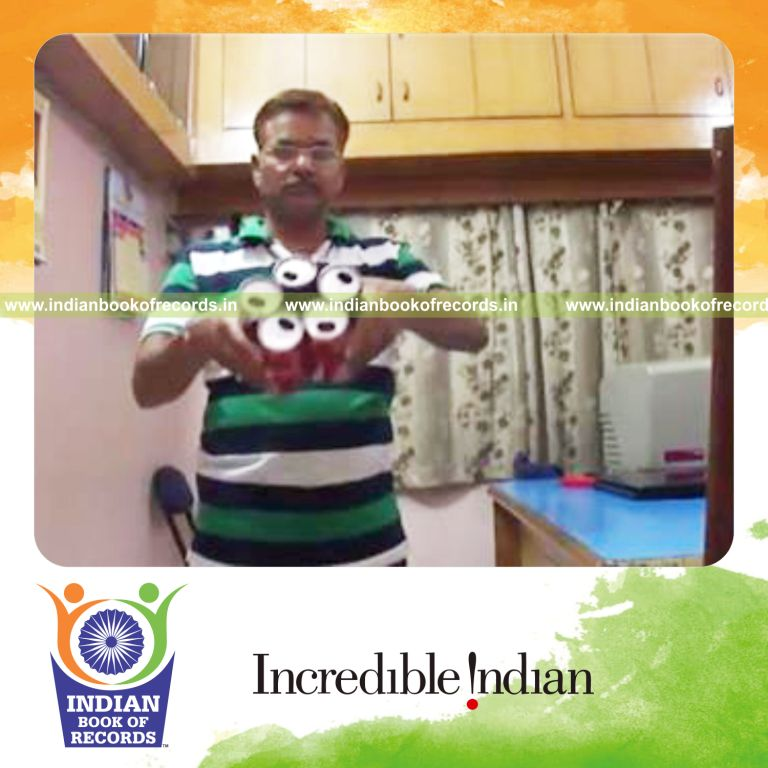 individual balancing five cans on left pinky finger for record in Indian Book of Records
