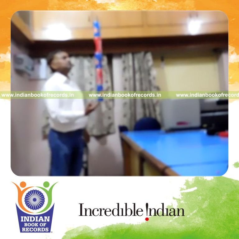 individual balancing five cans on right index finger for record in Indian Book of Records