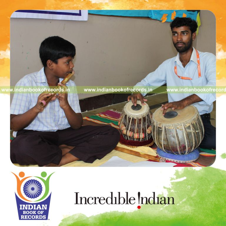 young male performing long flute concert for record in Indian Book of Records