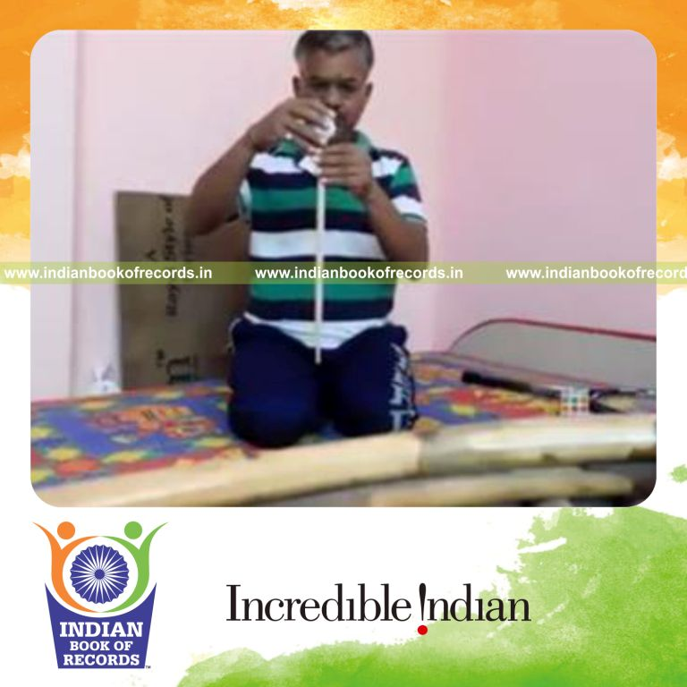 individual balancing golf ball on drumstick tip while kneeling for record in Indian Book of Records