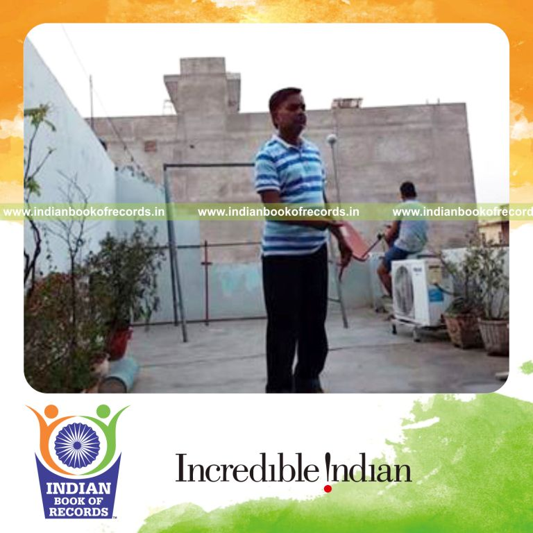 individual balancing golf ball on knitting needle on finger for record in Indian Book of Records