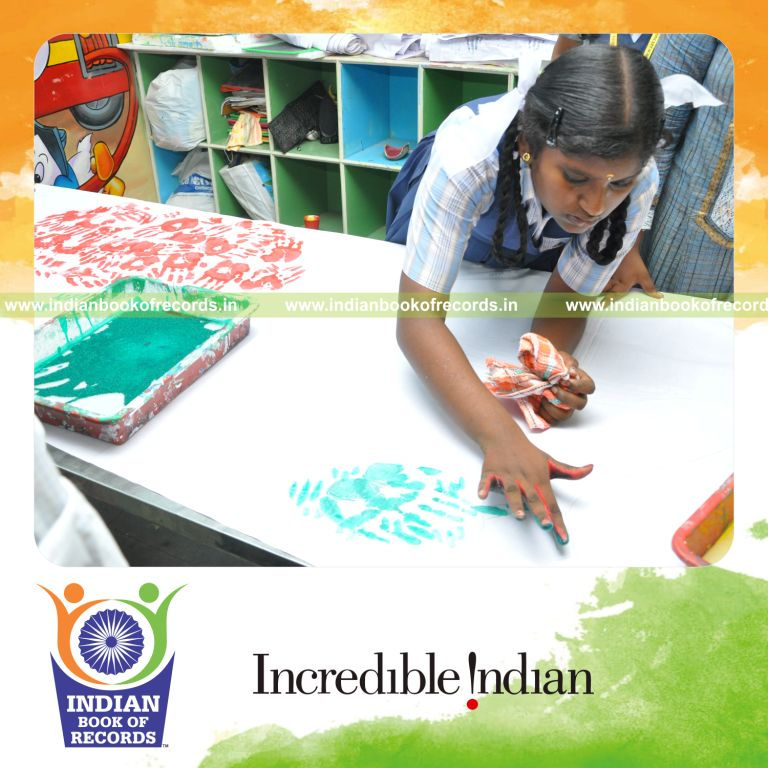 young female creating extended handprint painting for record in Indian Book of Records