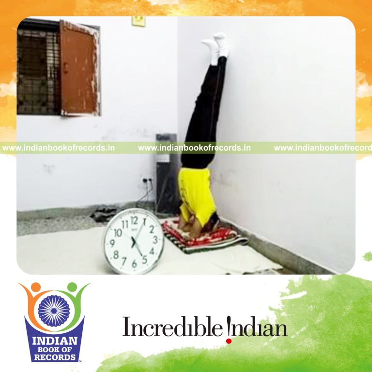 individual performing headstand against wall for longest time for record in Indian Book of Records