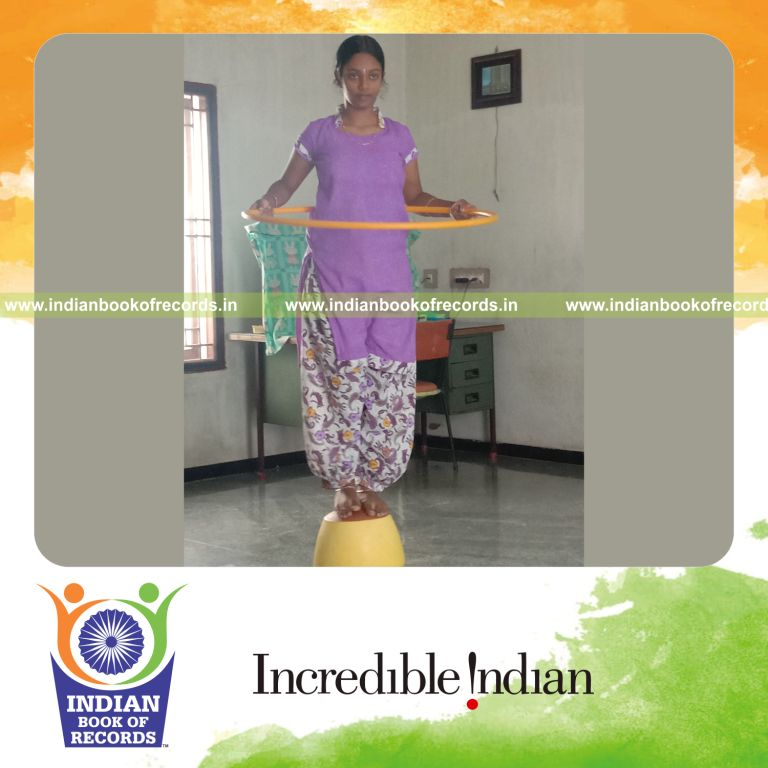 individual female performing hula hoop on inverted mud pot for longest duration for record in Indian Book of Records