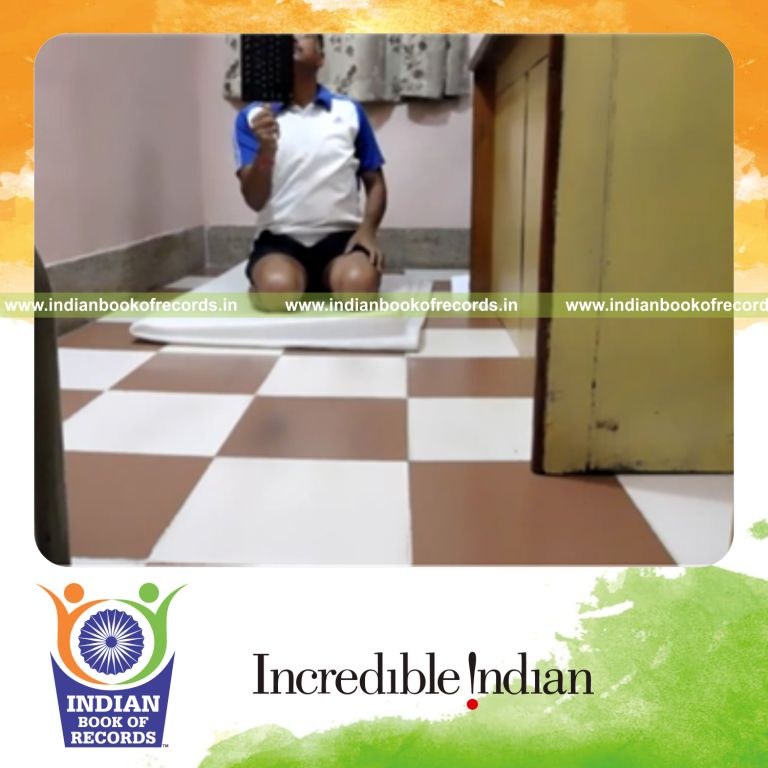 individual balancing keyboard on thumb while kneeling for record in Indian Book of Records