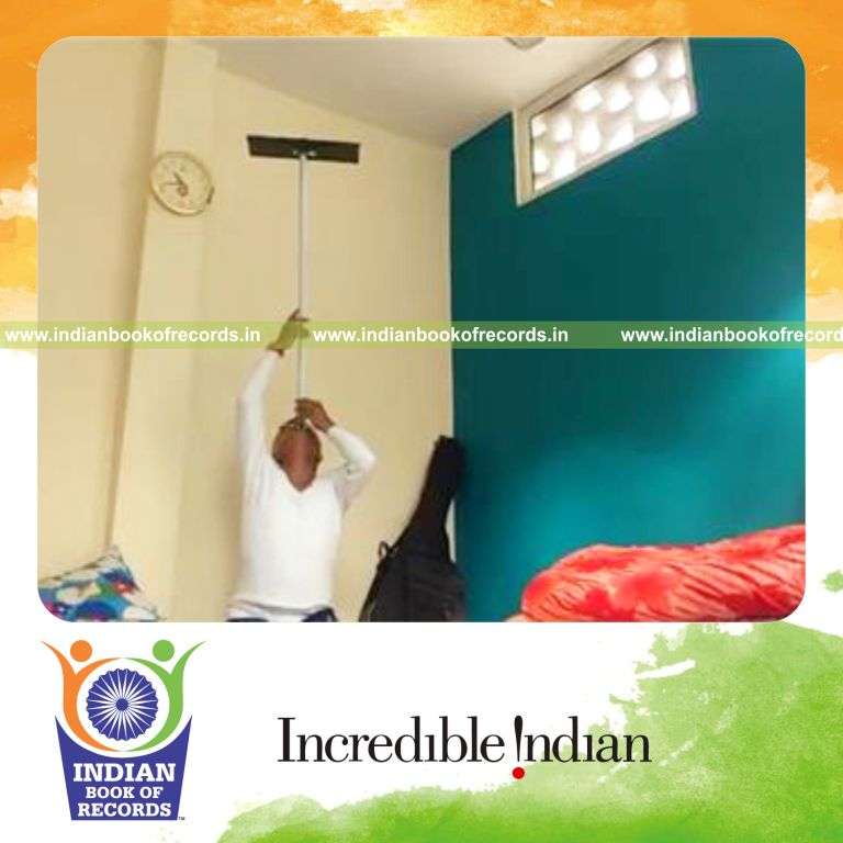 individual balancing keyboard on pole on chin while sitting for longest duration for record in Indian Book of Records