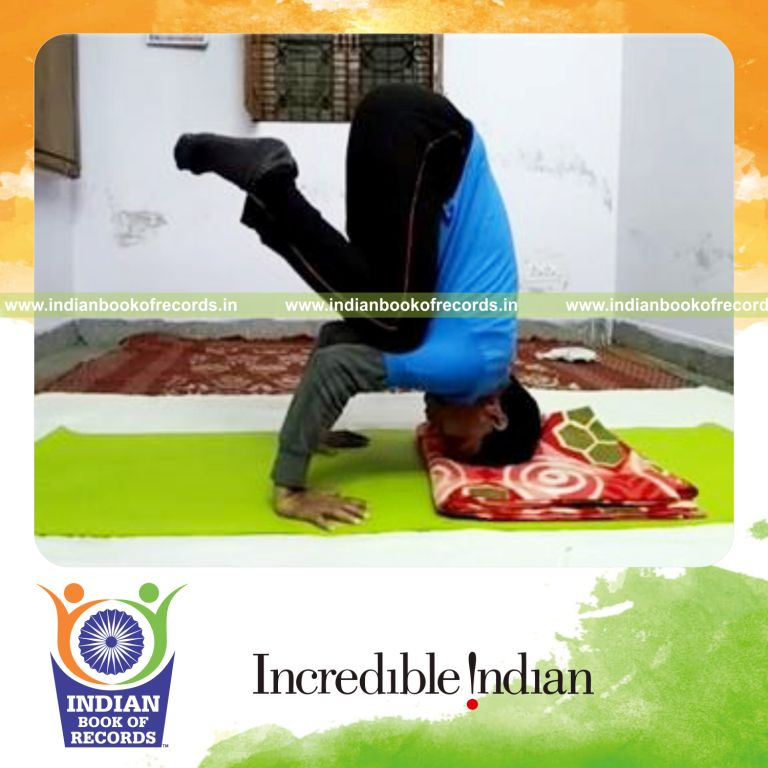 individual holding leaning crow pose touching head on ground for record in Indian Book of Records