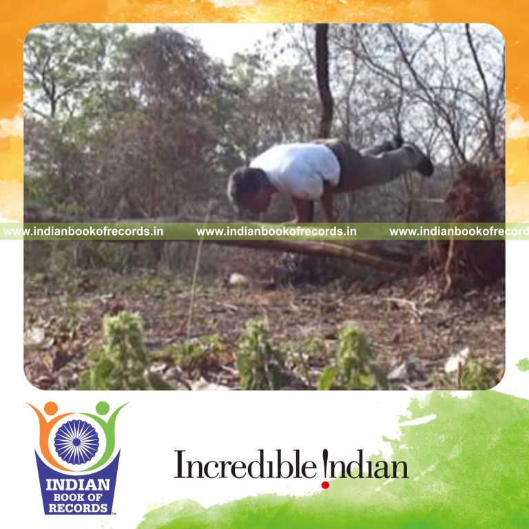 individual holding peacock pose on fallen tree for record in Indian Book of Records