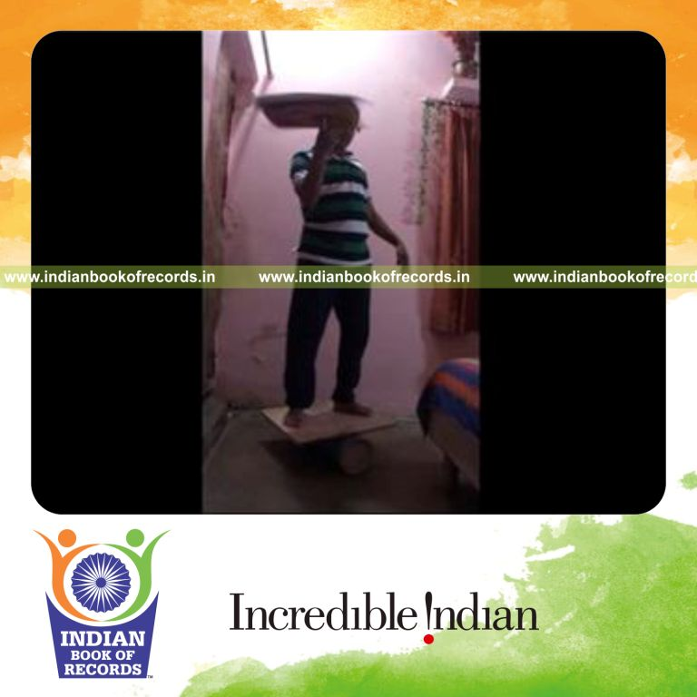 individual spinning pillow on finger while balancing on rola bola for record in Indian Book of Records