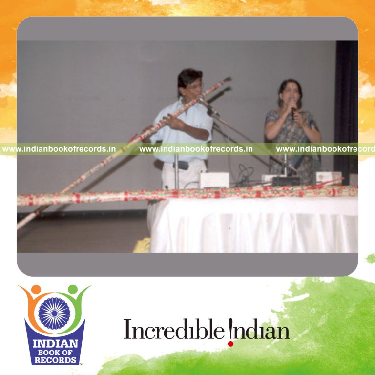 male individual creating longest playable flute for record in Indian Book of Records