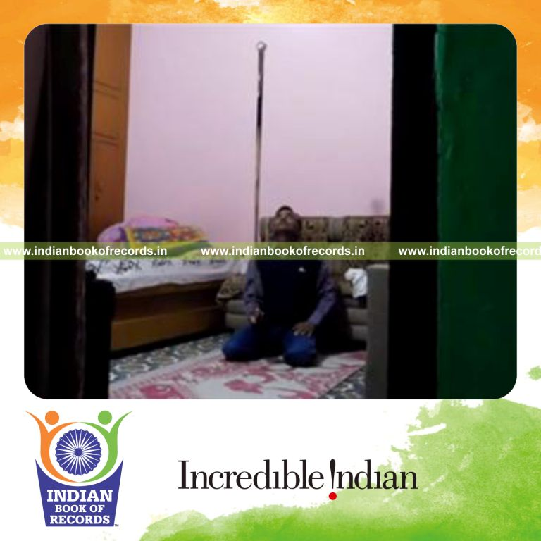 individual balancing pool ball on cue stick on finger while kneeling for record in Indian Book of Records