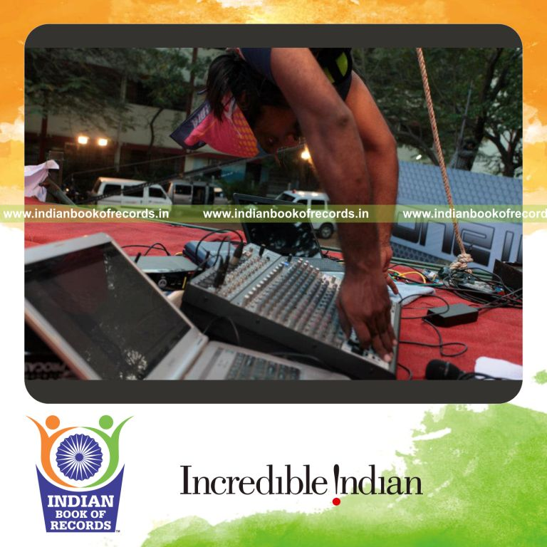 male individual performing radio dj set while suspended upside down for record in Indian Book of Records