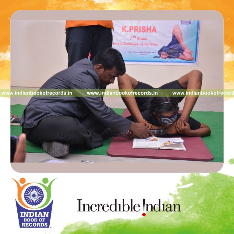 individual female reading book upside down while blindfolded holding viparitha kanda perundasana yoga pose for Indian Book of Records