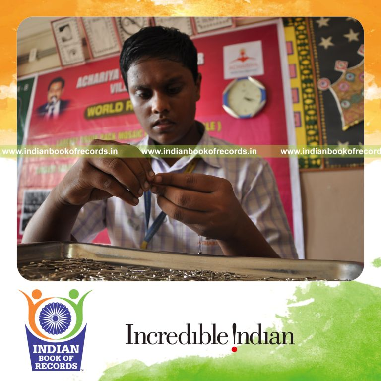young male creating safety pin chain within three hours for record in Indian Book of Records