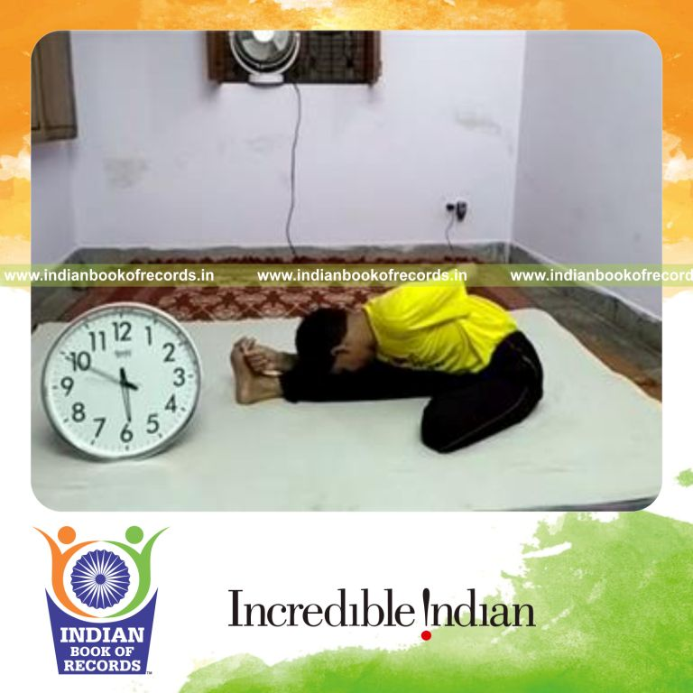 individual holding seated half bound lotus forward pose for record in Indian Book of Records