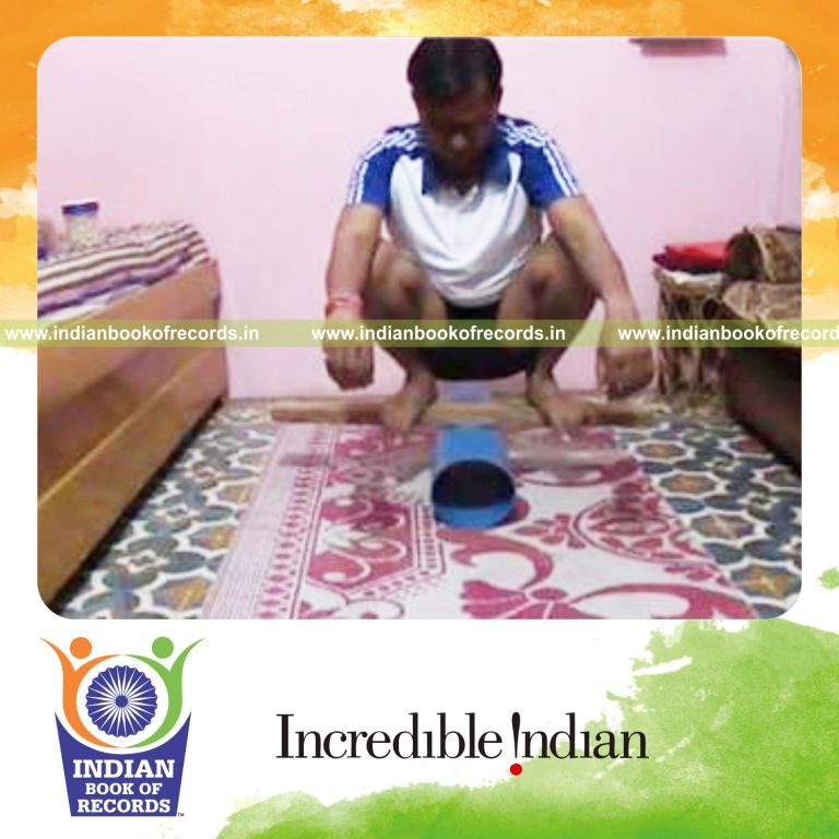 individual sitting on three inch wooden batten for record in Indian Book of Records