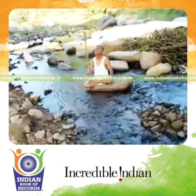 individual balancing stick on thumb while seated in lotus pose for record in Indian Book of Records
