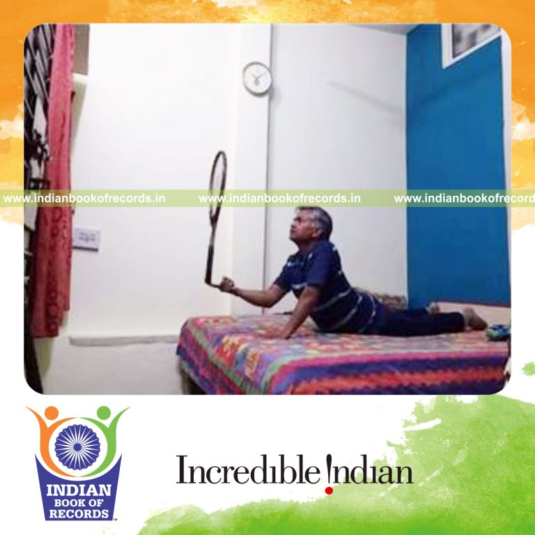 individual balancing tennis racquet on index finger while holding cobra pose for record in Indian Book of Records