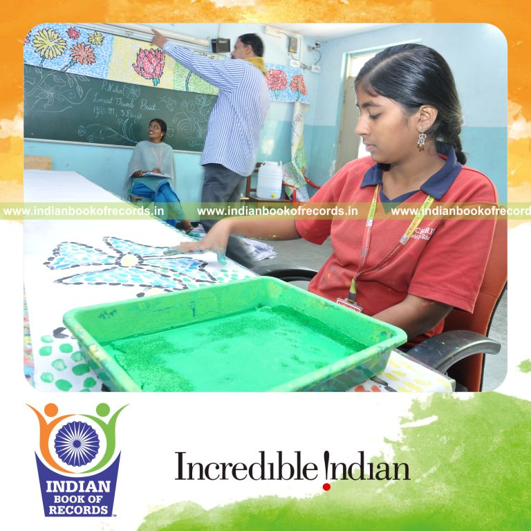 young female creating extended thumbprint painting for record in Indian Book of Records