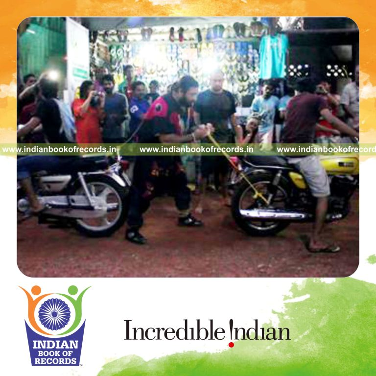 individual stopping two running motorcycles using hair and teeth for longest time for record in Indian Book of Records