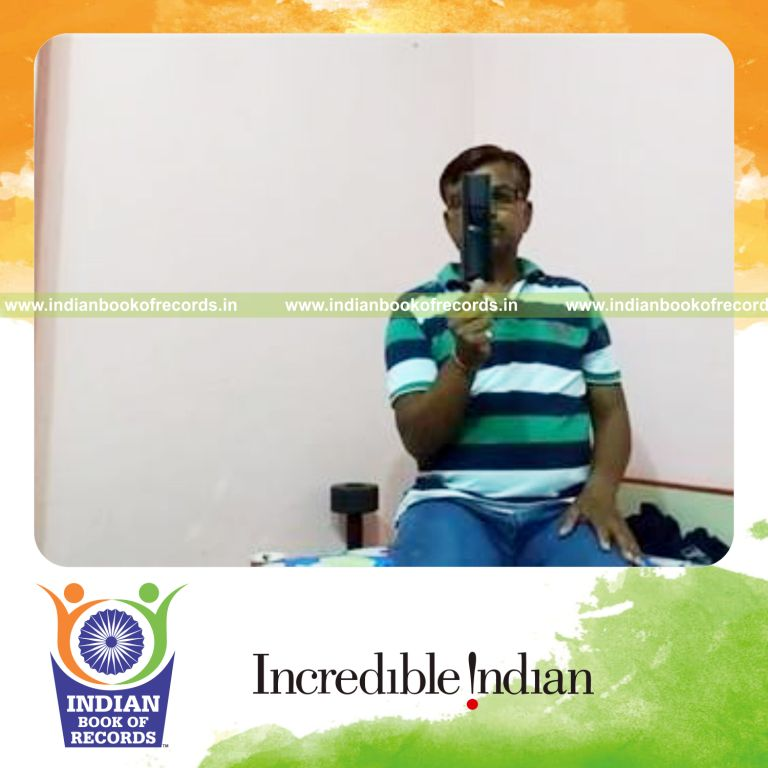 individual balancing tv remote on thumb while kneeling for record in Indian Book of Records