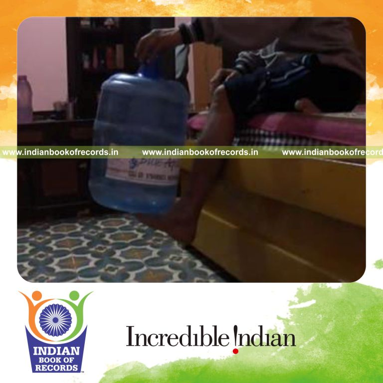 individual balancing five gallon water jug on left foot for record in Indian Book of Records