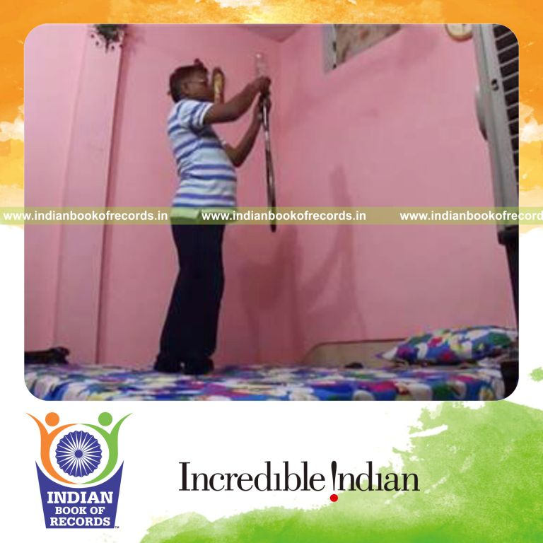individual balancing whiskey bottle on racquet handle on one finger for record in Indian Book of Records