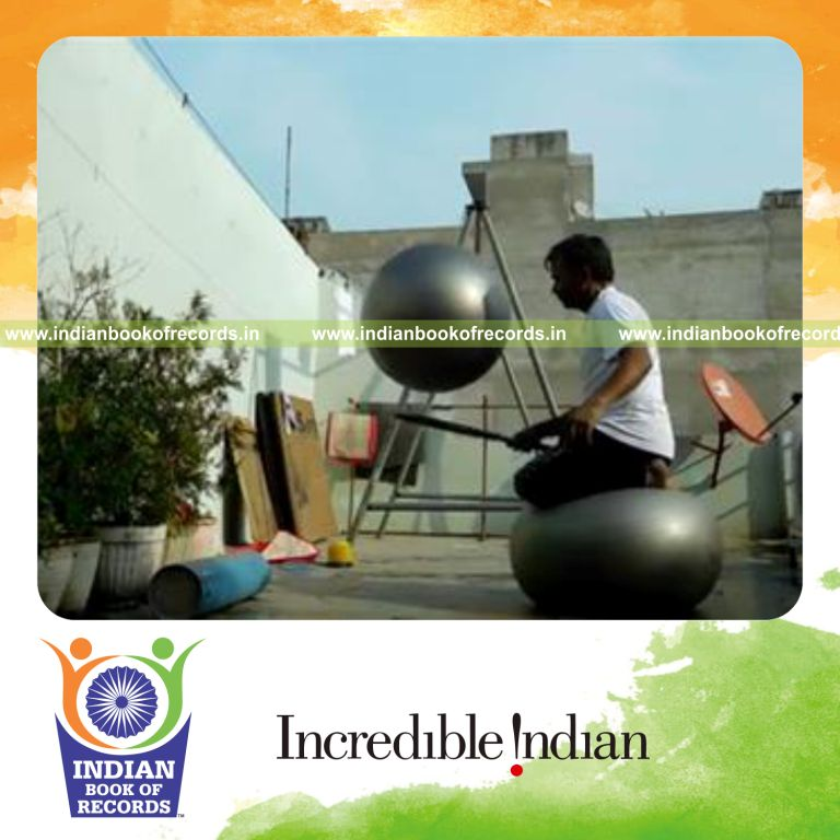 individual bouncing exercise ball on tennis racquet while kneeling on exercise ball for record in Indian Book of Records