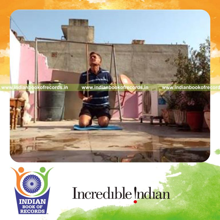 individual performing knee drops while balancing pool cue on hand for record in Indian Book of Records