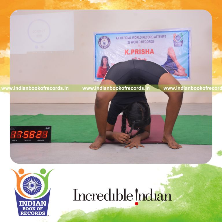 individual female performing knife stabs between fingers while holding bandha chakrasana blindfolded for Indian Book of Records