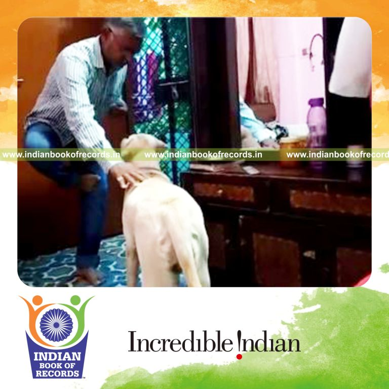 individual petting dog while standing on one foot for maximum count record in Indian Book of Records