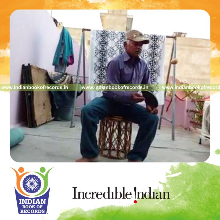 individual bouncing potato on paddle while sitting on potato for record in Indian Book of Records