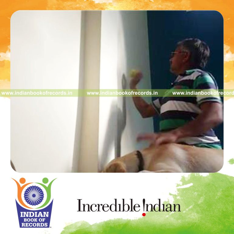 individual bouncing tennis ball off building while petting dog in 30 seconds for record in Indian Book of Records