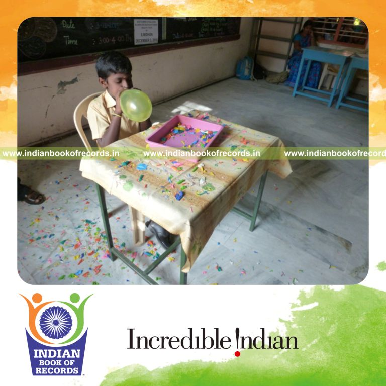 minor male blowing and bursting balloons continuously for Indian Book of Records