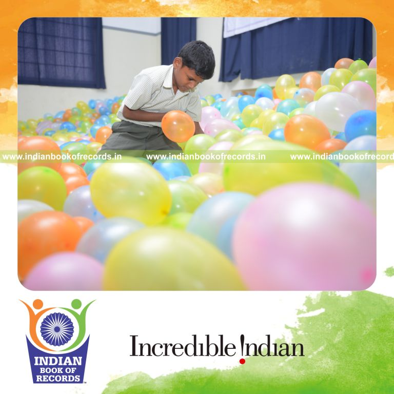 young boy bursting balloons rapidly for Indian Book of Records